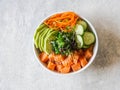 Hawaiian salmon poke bowl with rice, avocado, cucumber, carrot, chukka and sesame seeds on a gray background. top view Royalty Free Stock Photo