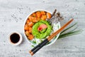 Hawaiian salmon poke bowl with seaweed, avocado rose, sesame seeds and scallions. Royalty Free Stock Photo