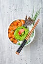 Hawaiian salmon poke bowl with seaweed, avocado rose, sesame seeds and scallions. Royalty Free Stock Photo