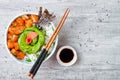 Hawaiian salmon poke bowl with seaweed, avocado rose, sesame seeds and scallions.