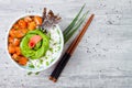 Hawaiian salmon poke bowl with seaweed, avocado rose, sesame seeds and scallions. Royalty Free Stock Photo