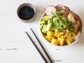 Hawaiian Shrimp Poke Bowl with Vegetables, mango and Rice on white wood background Royalty Free Stock Photo