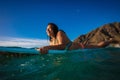 Hawaiian surfer girl in water on her surfing board