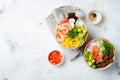 Hawaiian tuna and shrimp poke bowls with seaweed, avocado, mango, pickled ginger, sesame seeds. Royalty Free Stock Photo