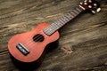 Hawaiian ukulele guitar on brown wooden background