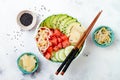 Hawaiian watermelon poke bowl with avocado, cucumber, mung bean sprouts and pickled ginger. Top view, overhead