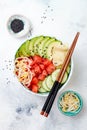 Hawaiian watermelon poke bowl with avocado, cucumber, mung bean sprouts and pickled ginger. Top view, overhead