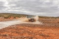 An All terrain Toyota Land Cruiser drives through a stream of water in the Australian Outback