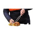 Hawkish rotisserie attendant cuts and serves grilled chicken- Royalty Free Stock Photo