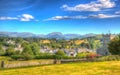 Traditional English country village in Lake District Hawkshead Cumbria in summer with blue sky church and red roses in colourful H