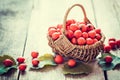 Hawthorn berries in basket on rustic table.