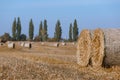 Hay bail harvesting in wonderful autumn farmers field landscape with hay stacks Royalty Free Stock Photo