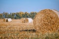 Hay bail harvesting in wonderful autumn farmers field landscape with hay stacks Royalty Free Stock Photo