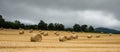 Hay bale field and beautiful overcast sky. Agriculture. Rural nature. Farm land. Yellow golden harvest in summer. Countryside Royalty Free Stock Photo