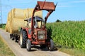 Tractor with hay bale transport countryside by harvest season Royalty Free Stock Photo