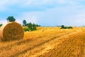 Hay bale. Wheat yellow golden harvest in summer. Beautiful landscape with lake on background. Royalty Free Stock Photo