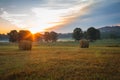 Hay bales rolled on field at sunrise with fog creates amazing sky in early summer Royalty Free Stock Photo