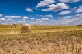 Hay bales under cloudy sky on harvested wheat field Royalty Free Stock Photo