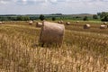 Hay bales under cloudy sky on harvested wheat field Royalty Free Stock Photo