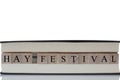 Hay Festival written on wooden blocks inside a book isolated on a white background Royalty Free Stock Photo