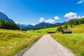 Hay huts and road in the Humpback Meadows between Mittenwald and Kruen, Germany Royalty Free Stock Photo