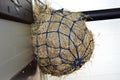 A hay net full of teff hay hanging in a horse box