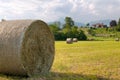 Hay roll foreground and background rural house Royalty Free Stock Photo
