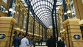 people walking into Hay's Galleria, a redeveloped warehouse and wharf under a curved glass ceiling