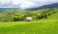 Hay shed on a grassy field in mountains Royalty Free Stock Photo