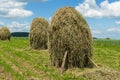 Hay stacks on farmland against the blue sky Royalty Free Stock Photo