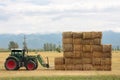 Hay tractor stacking hay bales on a big pile Royalty Free Stock Photo