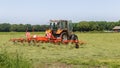 Hay truning to dry grass in the sun on the field in the Netherlands Royalty Free Stock Photo