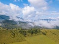 Hayfields on the Mountain Slope and Clouds over Forest. Aerial View Royalty Free Stock Photo