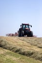Haymaking: tractor turning hay. Royalty Free Stock Photo