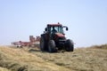 Haymaking: tractor turning hay. Royalty Free Stock Photo