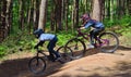 Two boys on downhill mountain bike course in woods.
