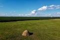 Haystack on a farm field on a sunny summer day, view from the top. Farm land