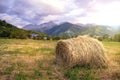 Haystack on the field with mountains on the background Royalty Free Stock Photo