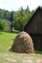 Haystack in front of wooden house from the 19th century