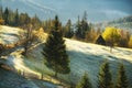 Haystack in a glade covered with frost overlooking the autumn mountains. Dirt road in the mountainous area.