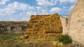 Haystack next to the barn. Stacked straw bales of hay. Square haystack under the open sky. Animal feed. Agricultural background. Royalty Free Stock Photo