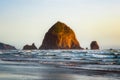 The Haystack Rock sea stack at high tide at sunset. Natural iconic landmark located in Cannon Beach, Oregon Coast Royalty Free Stock Photo