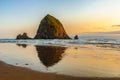 Haystack Rock at sunset with reflection on the sandy shore, Cannon Beach, Pacific Coast, Oregon, USA Royalty Free Stock Photo
