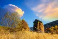 Haystack under wooden roof built behind fence in highland Royalty Free Stock Photo