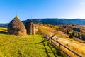 Haystack under wooden roof built behind fence in highland Royalty Free Stock Photo