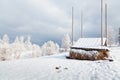 Haystack on the winter field covered with snow, trees in hoarfrost. Royalty Free Stock Photo