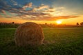 Haystacks on green field under the beautiful blue cloudy sky at sunset Royalty Free Stock Photo