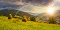 Haystacks on hillside near the village at sunset Royalty Free Stock Photo