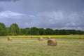 Haystacks on a mown field under thunderclouds Royalty Free Stock Photo