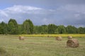 Haystacks on a mown field under thunderclouds Royalty Free Stock Photo